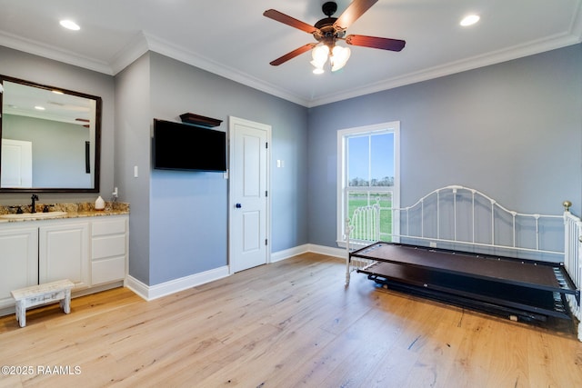 bedroom featuring crown molding, sink, and light hardwood / wood-style flooring