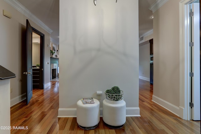 hall with wood-type flooring and crown molding