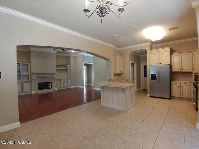 kitchen featuring a notable chandelier, light tile patterned flooring, stainless steel fridge with ice dispenser, and crown molding