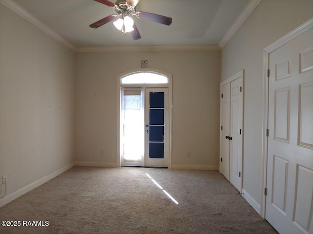 carpeted empty room featuring ceiling fan and crown molding