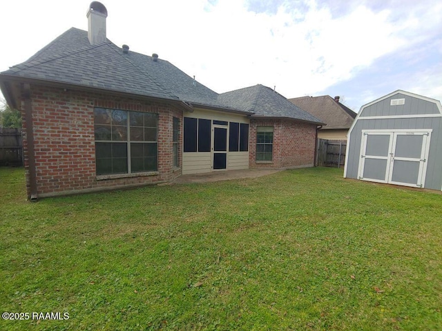 rear view of house featuring a lawn, a patio area, and a storage shed