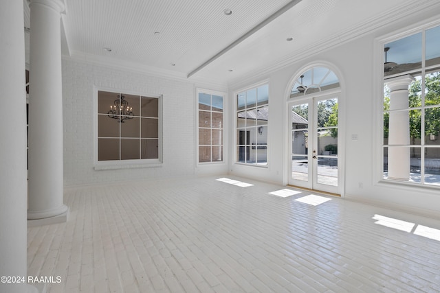 unfurnished sunroom featuring french doors, a chandelier, and decorative columns