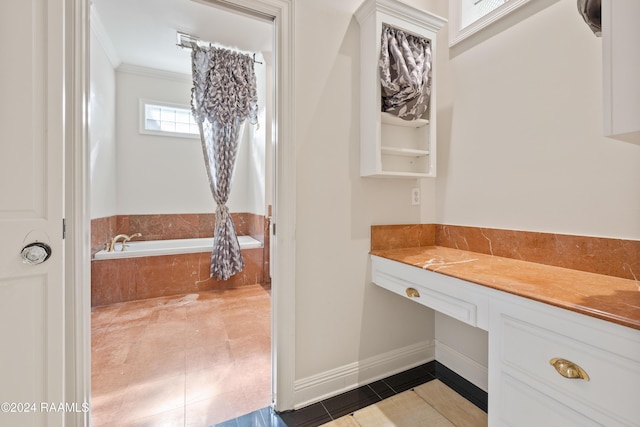 bathroom with tile patterned flooring, crown molding, and tiled bath