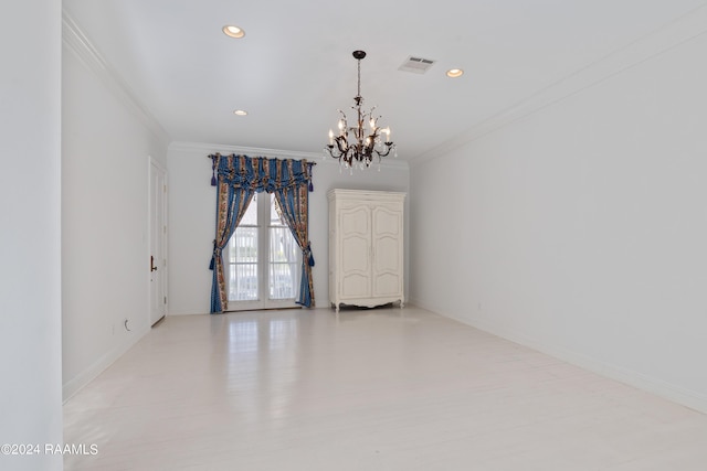 empty room featuring crown molding, light hardwood / wood-style flooring, and a chandelier