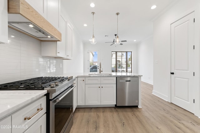 kitchen featuring sink, white cabinets, exhaust hood, and appliances with stainless steel finishes