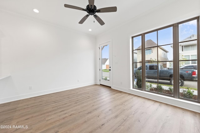 empty room with light hardwood / wood-style flooring, plenty of natural light, ornamental molding, and ceiling fan