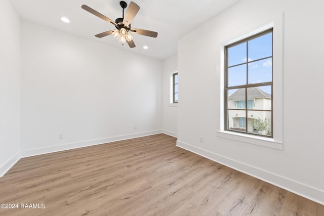 empty room with ceiling fan and light hardwood / wood-style floors