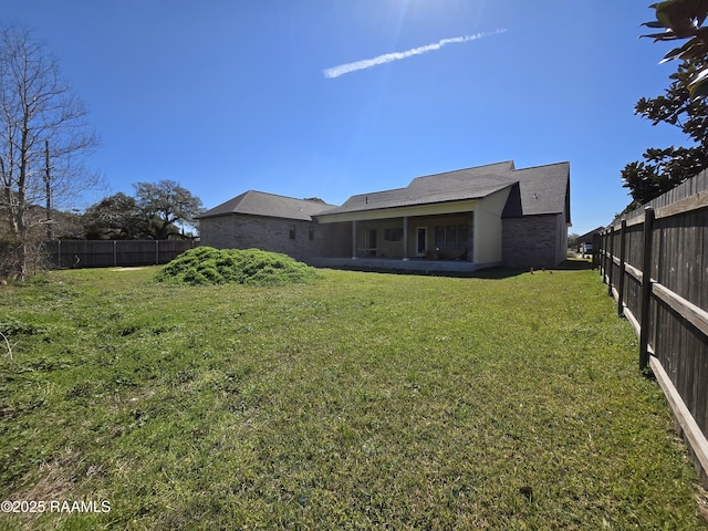 rear view of property with a yard and a fenced backyard