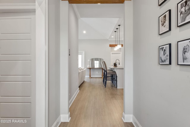 hall with light hardwood / wood-style flooring and sink