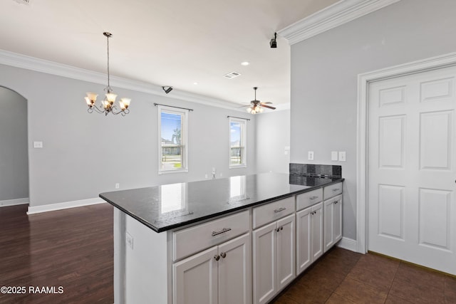 kitchen with hanging light fixtures, kitchen peninsula, white cabinets, ceiling fan with notable chandelier, and ornamental molding