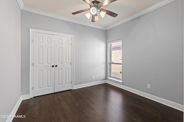 unfurnished bedroom with ceiling fan, a closet, dark hardwood / wood-style floors, and ornamental molding