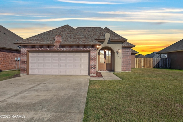 view of front of home with a garage and a lawn