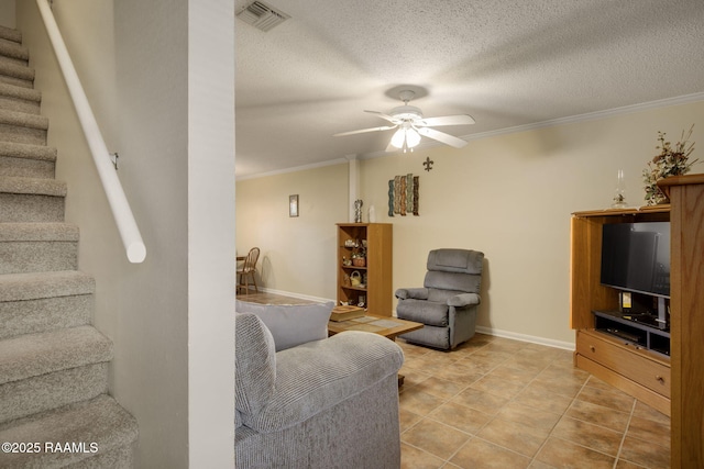 living room featuring crown molding, ceiling fan, and a textured ceiling