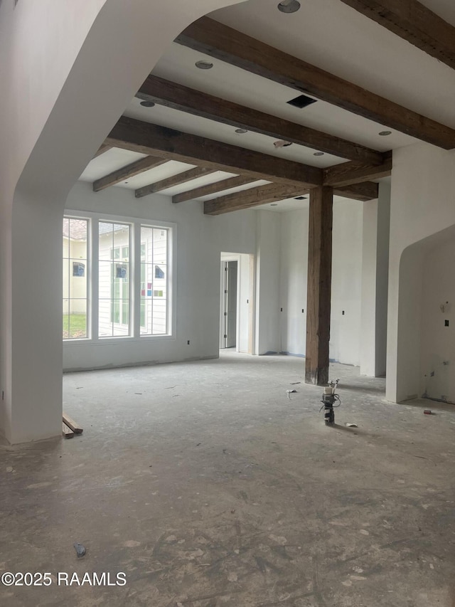 unfurnished living room with beam ceiling