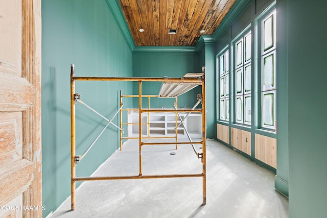 unfurnished bedroom with concrete flooring, ornamental molding, and wood ceiling