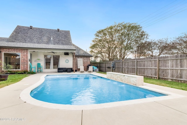 view of pool with ceiling fan, pool water feature, and a patio