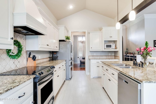 kitchen with premium range hood, vaulted ceiling, decorative light fixtures, white cabinets, and appliances with stainless steel finishes