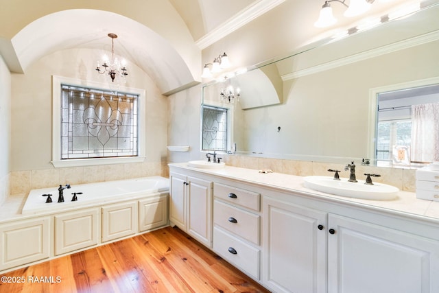 bathroom featuring vanity, a bath, hardwood / wood-style flooring, a chandelier, and lofted ceiling