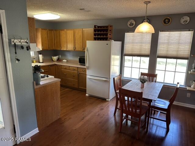 6757 Line Rd, Ethel, LA 70730 - kitchen with freestanding refrigerator, dark wood-type flooring, a textured ceiling, light countertops, and stainless steel microwave