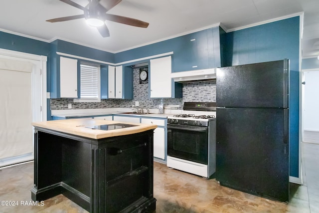 kitchen with black fridge, white range with gas cooktop, ceiling fan, sink, and a kitchen island