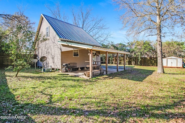 back of house featuring central AC unit, a patio area, a yard, and a shed