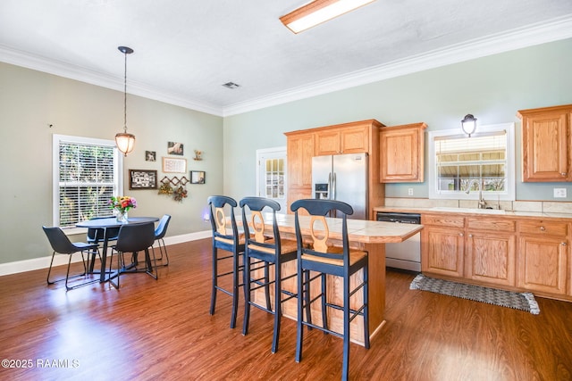 kitchen featuring crown molding, sink, dark hardwood / wood-style floors, a kitchen island, and stainless steel appliances