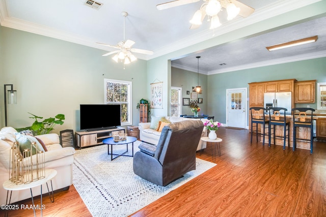 living room featuring dark hardwood / wood-style floors, ceiling fan, and ornamental molding