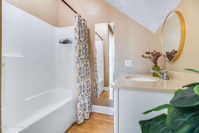 bathroom with shower / bath combo with shower curtain, wood-type flooring, vanity, and vaulted ceiling