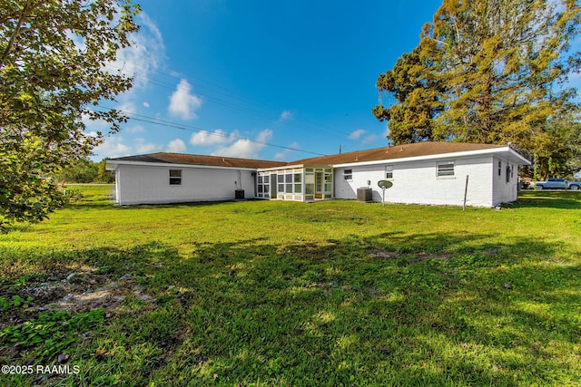 rear view of property featuring a sunroom and a yard