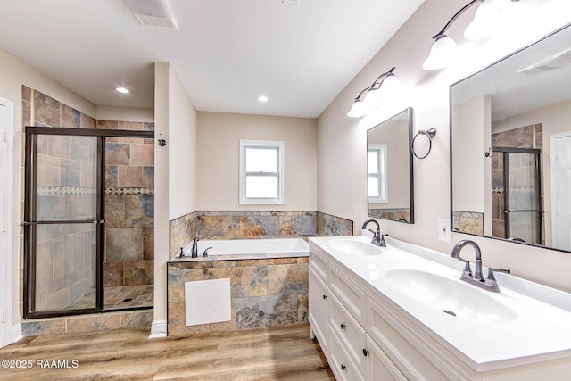 bathroom with hardwood / wood-style floors, vanity, and independent shower and bath