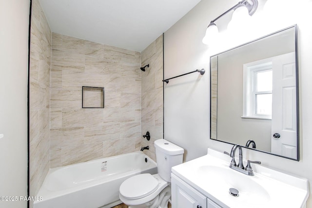 full bathroom with toilet, vanity, and tiled shower / bath