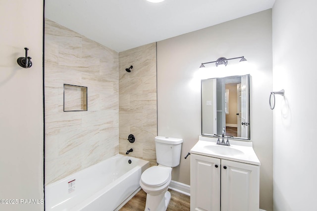 full bathroom with vanity, hardwood / wood-style floors, tiled shower / bath combo, and toilet