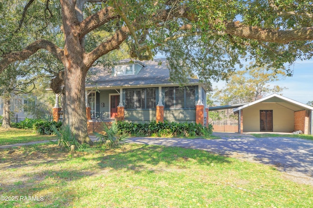 view of front of house featuring a front lawn, a carport, and a sunroom