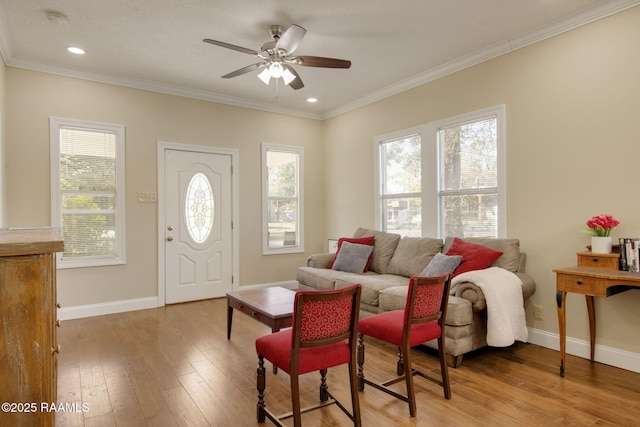 living room with ceiling fan, light hardwood / wood-style floors, crown molding, and a healthy amount of sunlight