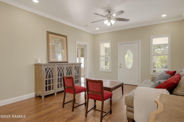 interior space featuring ceiling fan, a wealth of natural light, crown molding, and light wood-type flooring