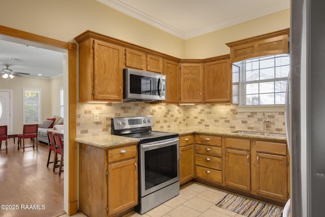 kitchen featuring decorative backsplash, appliances with stainless steel finishes, sink, and ornamental molding