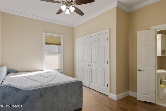 bedroom featuring ceiling fan, wood-type flooring, a closet, and crown molding