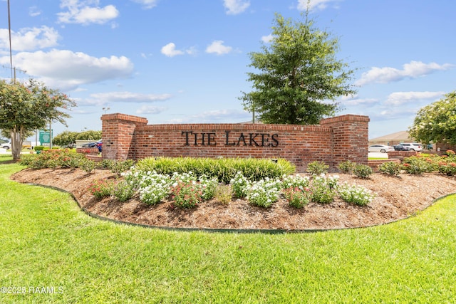 community / neighborhood sign featuring a lawn