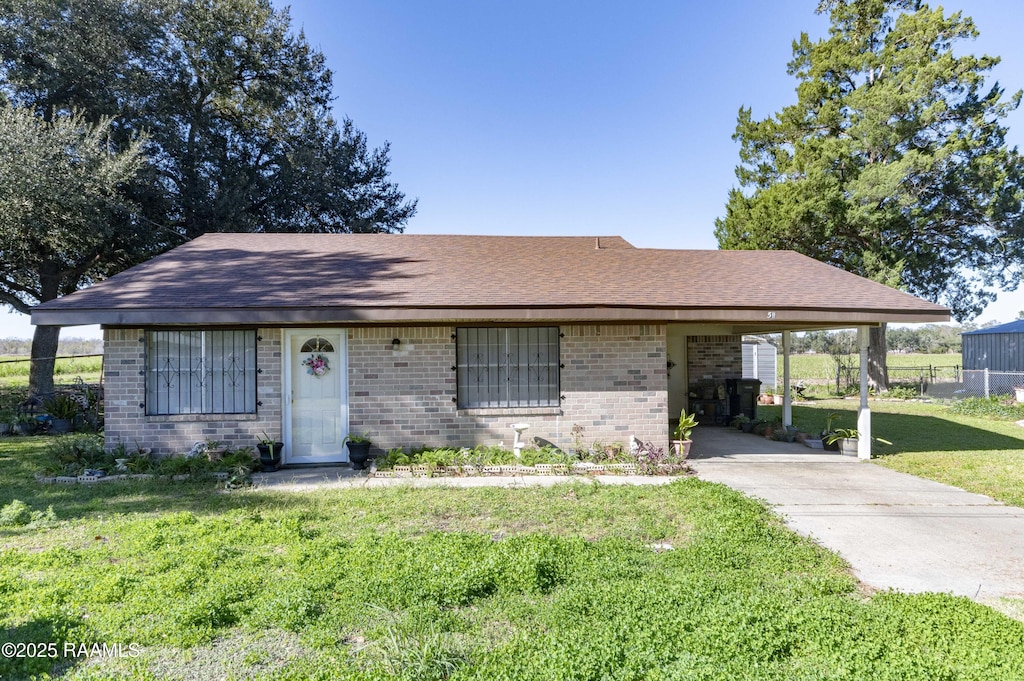 ranch-style house with a front yard and a carport
