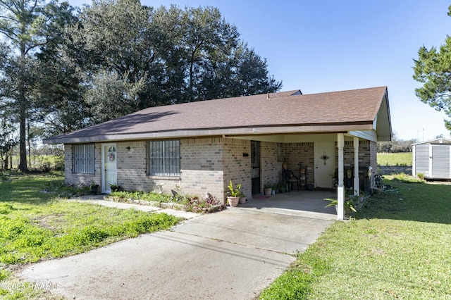 ranch-style house with a front lawn, a storage unit, and a carport