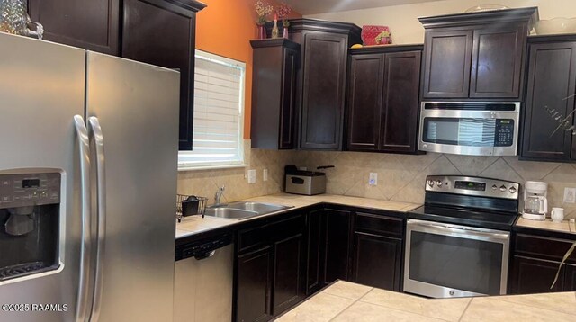 kitchen with tasteful backsplash, sink, dark brown cabinetry, and appliances with stainless steel finishes