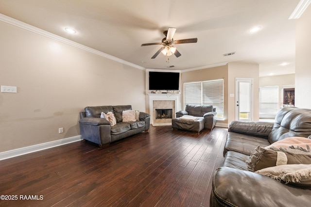 living room with a fireplace, ornamental molding, dark hardwood / wood-style floors, and ceiling fan