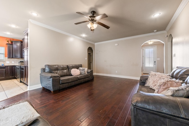 living room featuring crown molding, ceiling fan, and light wood-type flooring