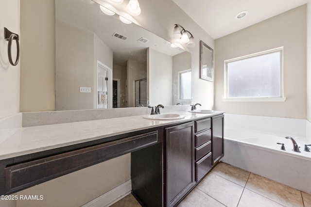 bathroom featuring tile patterned floors, vanity, and a washtub