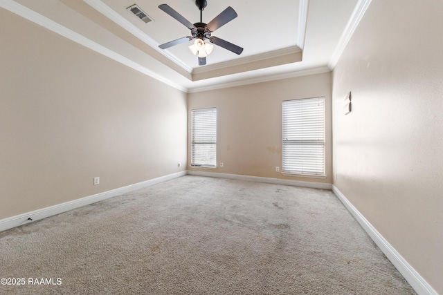 spare room with a raised ceiling, crown molding, light carpet, and ceiling fan