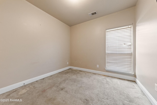 spare room featuring light colored carpet