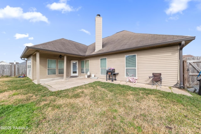 rear view of house with a patio area and a lawn