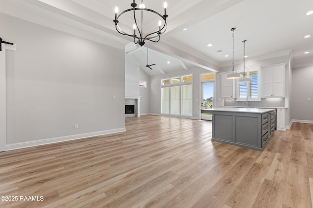 kitchen featuring white cabinetry, gray cabinets, a kitchen island, pendant lighting, and a barn door