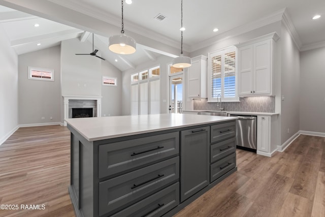 kitchen featuring a kitchen island, decorative light fixtures, tasteful backsplash, white cabinetry, and stainless steel dishwasher