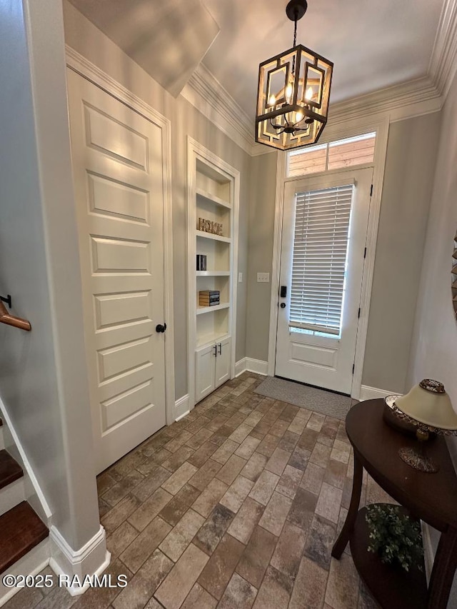 doorway to outside featuring a notable chandelier, built in features, and ornamental molding